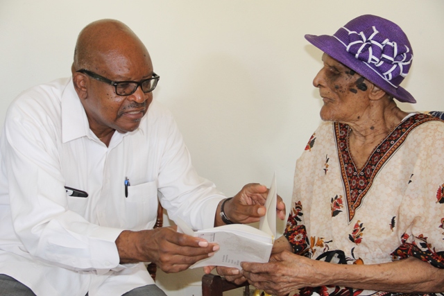 Governor General of St. Kitts and Nevis His Excellency Sir Tapley Seaton presents a royal birthday card from Her Majesty Queen Elizabeth II to centenarian Eileen Swanston Smithen at her home in Zion Village, Gingerland on July 13, 2017, after some mailing delay